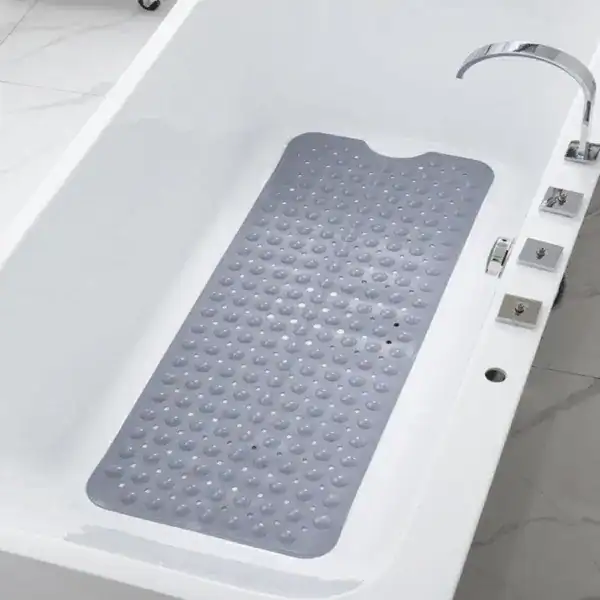 Grijze antislip badmat met bolletjes in witte badkuip.