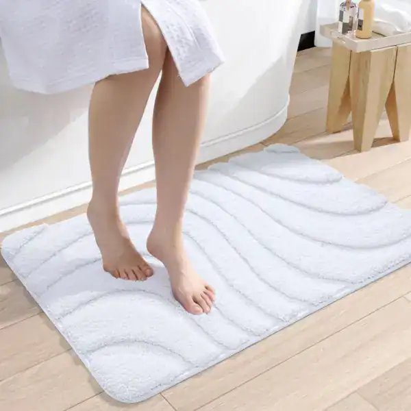 Witte badkamermat met golfvormige textuur voor extra grip en comfort.