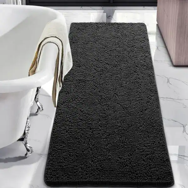 Zwarte badmat met antislip textuur in een moderne badkamer.
