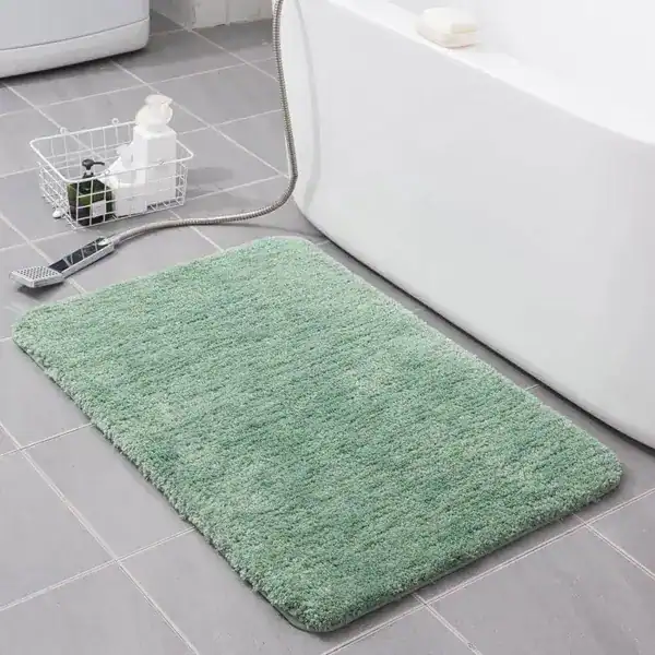 Groene badmat 80x100 in badkamer naast bad, antislip en comfortabel.