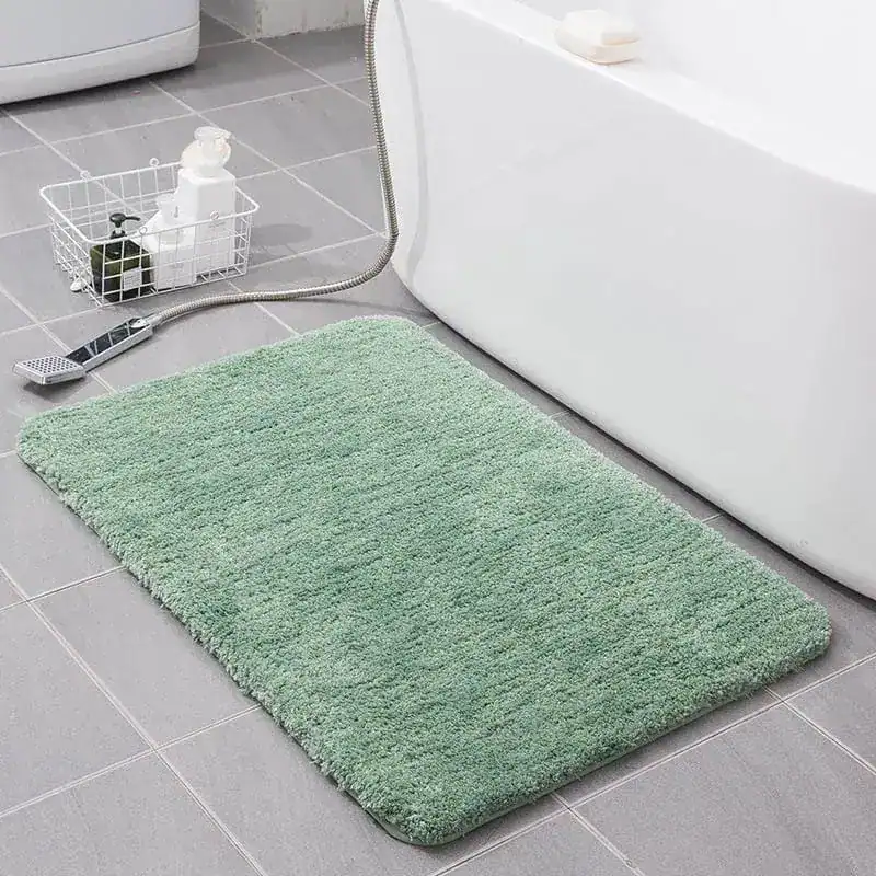 Groene badmat 80x100 in badkamer naast bad, antislip en comfortabel.