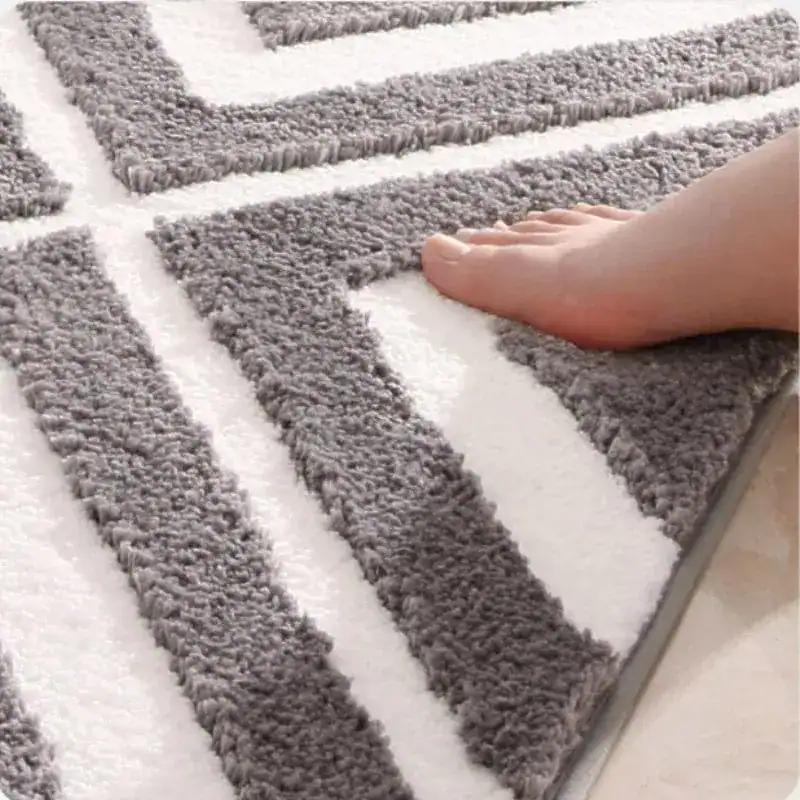 Badmat aqua blauw met grijs-witte geometrische patronen en antislipoppervlak.