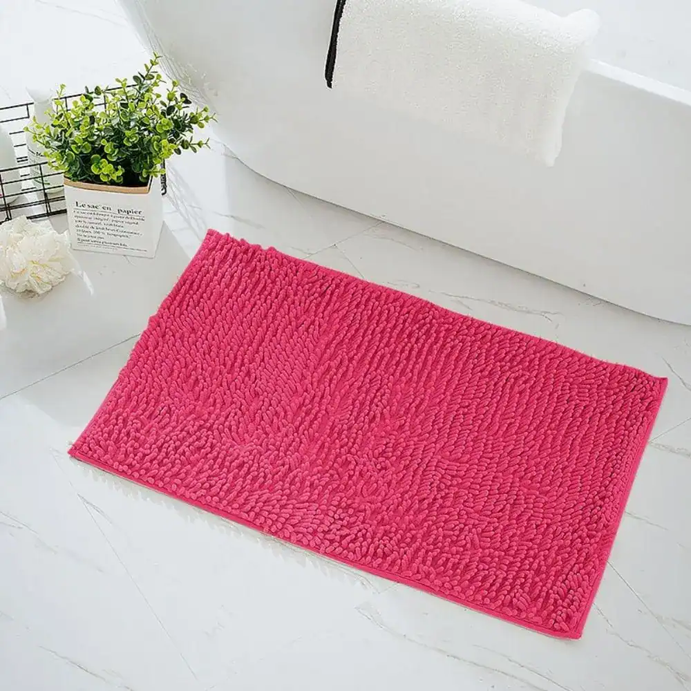 Fuchsia badmat met antislip textuur in de badkamer.