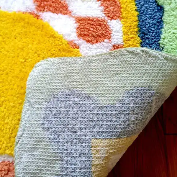 Goudkleurige badmat met antislip onderkant, close-up van textuur en kleuren.