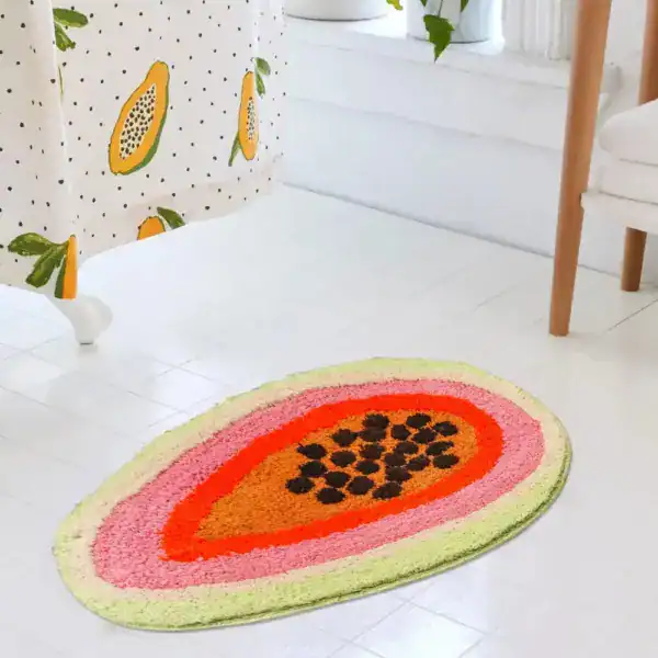Grappige badmat in vorm van een papaja met kleurrijke ringen en zaden.