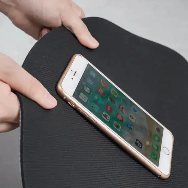 Grijs witte badmat met antislipoppervlak, getoond met een smartphone.