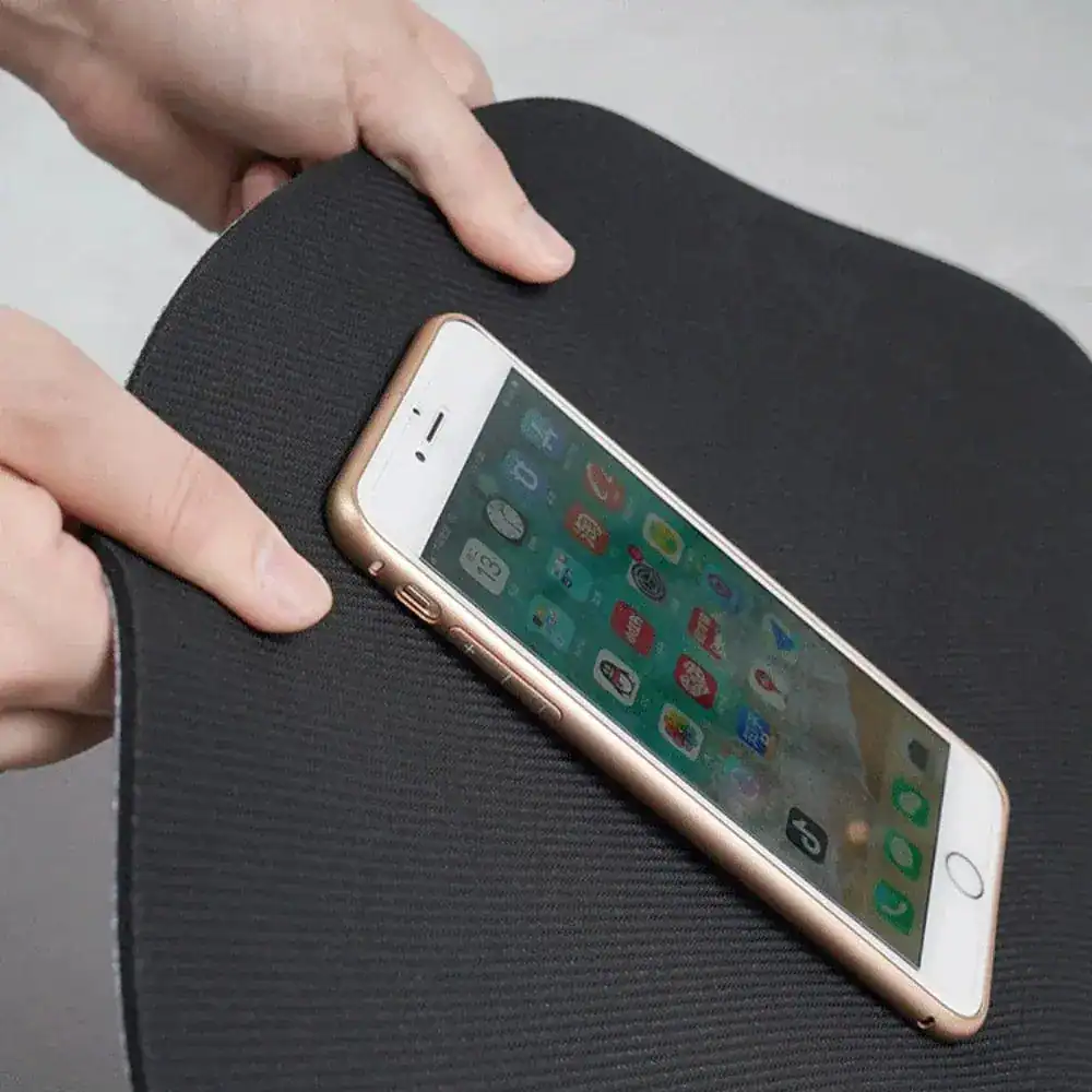 Grijs witte badmat met antislipoppervlak, getoond met een smartphone.