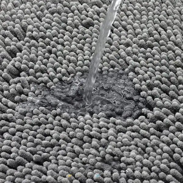 Grijze ronde badmat met antislip textuur, water stroomt erover.