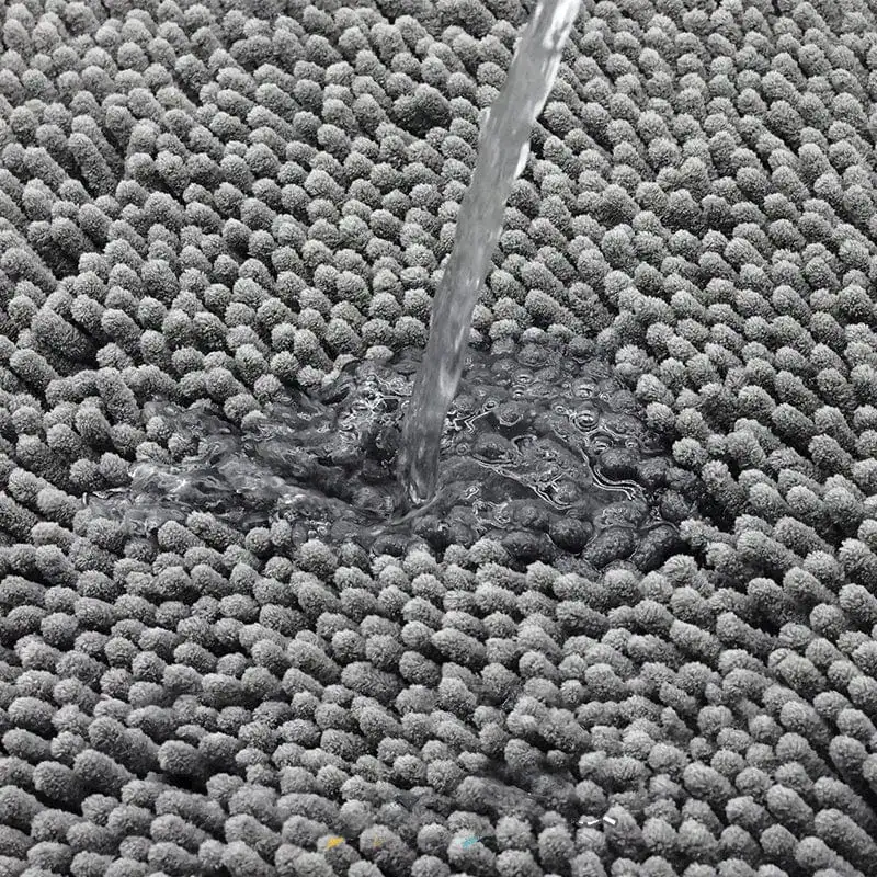 Grijze ronde badmat met antislip textuur, water stroomt erover.