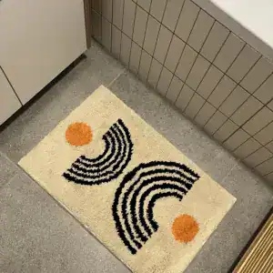 Beige badmat met abstracte bogen en oranje accenten in een betegelde badkamer