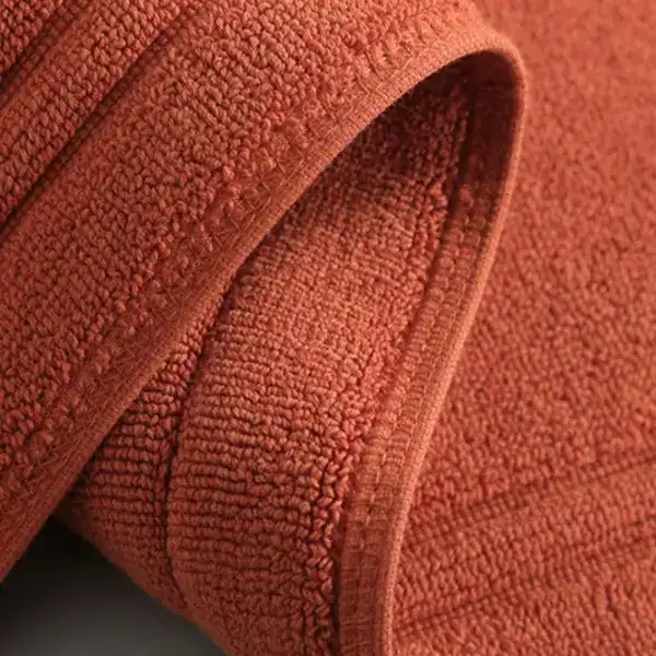 Badmat katoen antislip, warme terracotta kleur, zachte textuur.