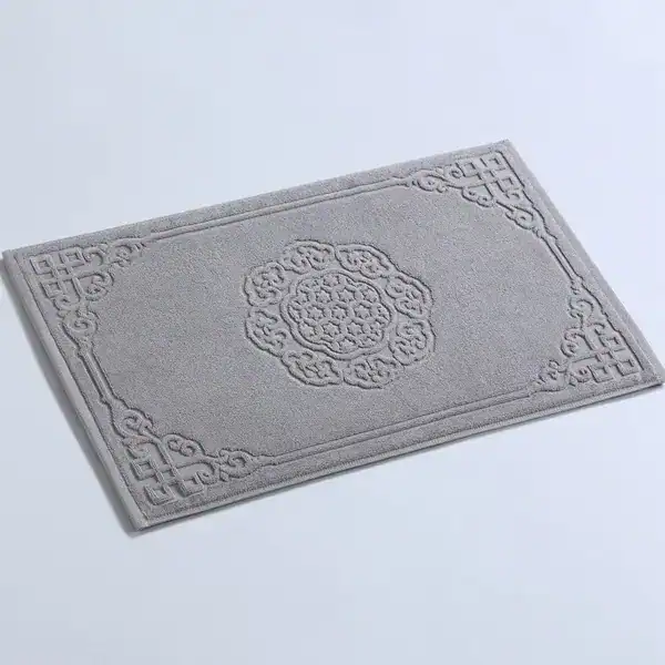 Grijze badmat katoen met antislip textuur en elegante borduurwerk.