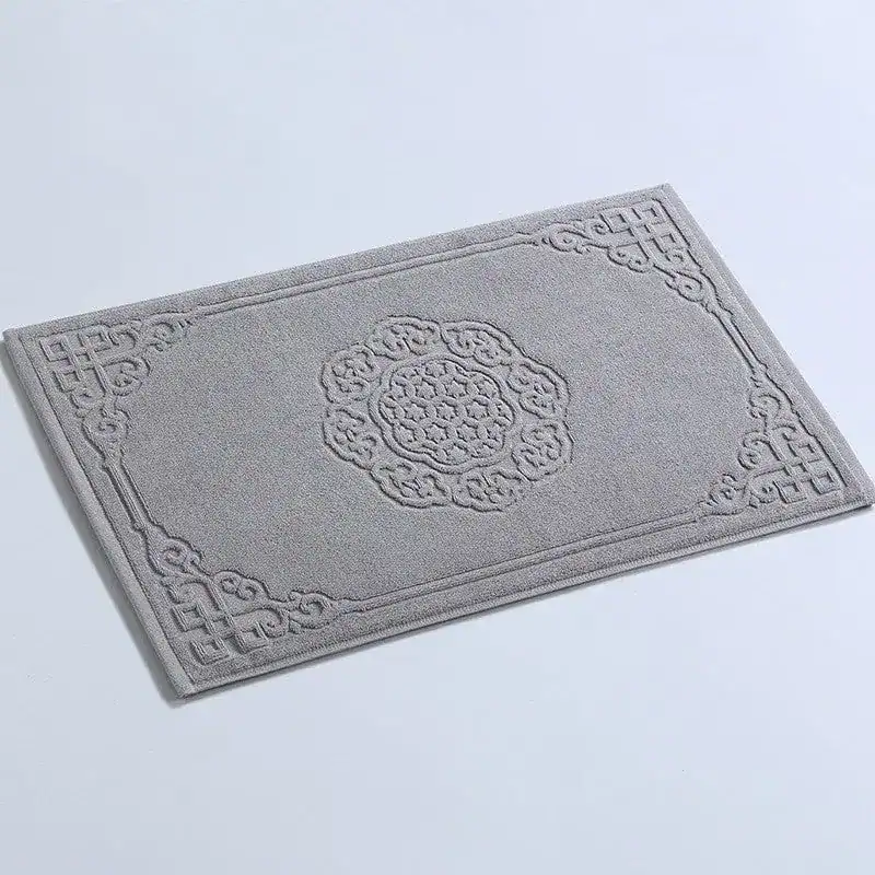 Grijze badmat katoen met antislip textuur en elegante borduurwerk.