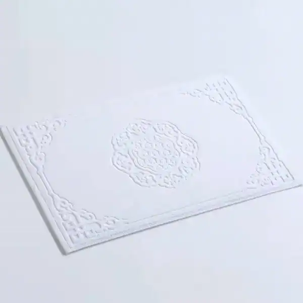 Wit badmat katoen met antislip textuur en elegante borduursel.