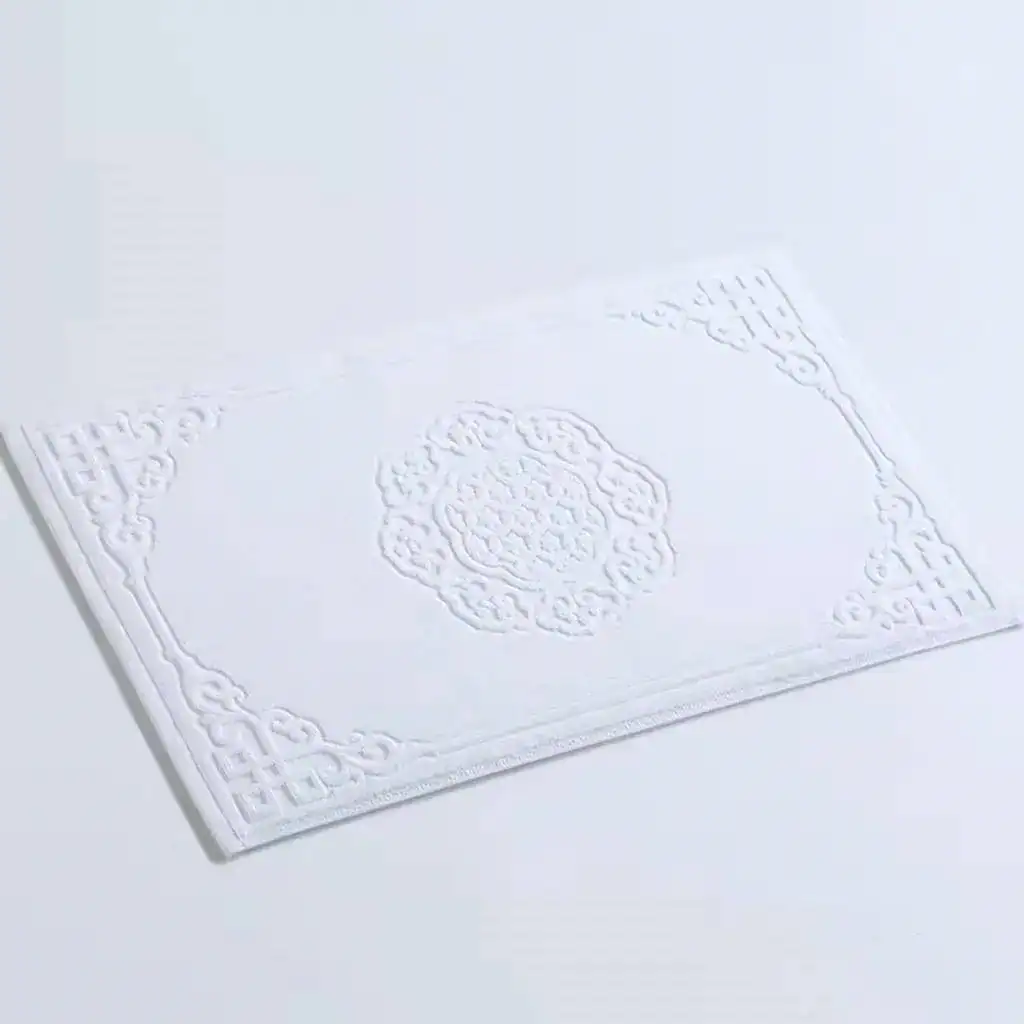 Wit badmat katoen met antislip textuur en elegante borduursel.