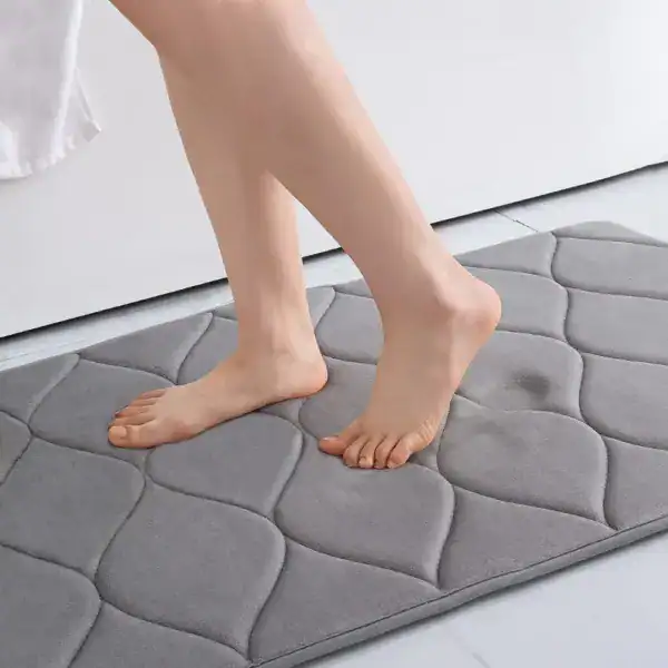 Grijze badmat met noppen voor extra grip in de badkamer.