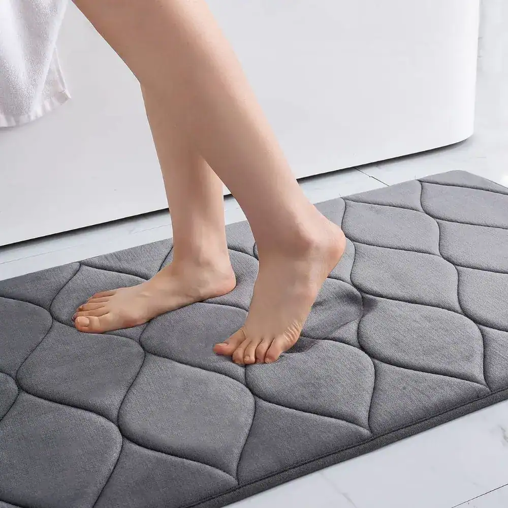 Grijze badmat met noppen voor antislip in de badkamer.