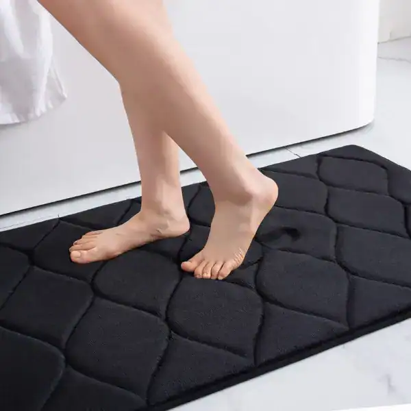 Zwarte badmat met noppen voor extra grip in de badkamer.