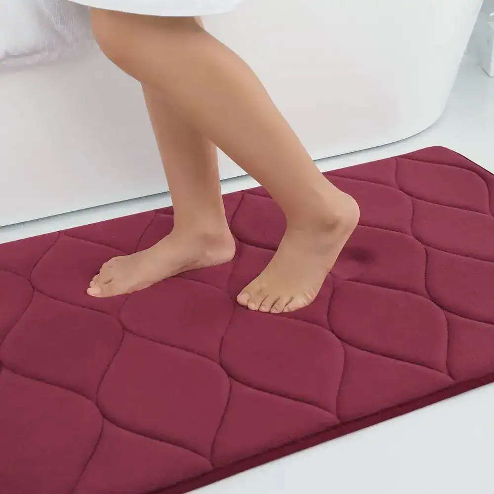 Rode badmat met noppen voor extra grip in de badkamer.