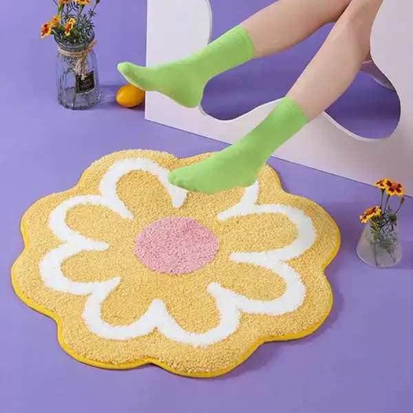 Badmat in bloemvorm met mosterdgele kleur en witte rand, geschikt als badkamermat of douchemat.