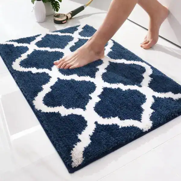 Donkerblauwe badkamermat met witte geometrische patroon, antislip en zachte textuur.
