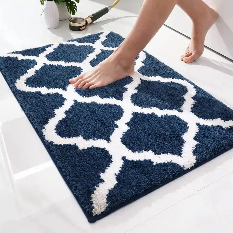 Donkerblauwe badkamermat met witte geometrische patroon, antislip en zachte textuur.