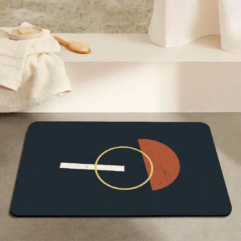 Donkere badmat met geometrisch ontwerp in oranje en goud, voor een moderne badkamer.