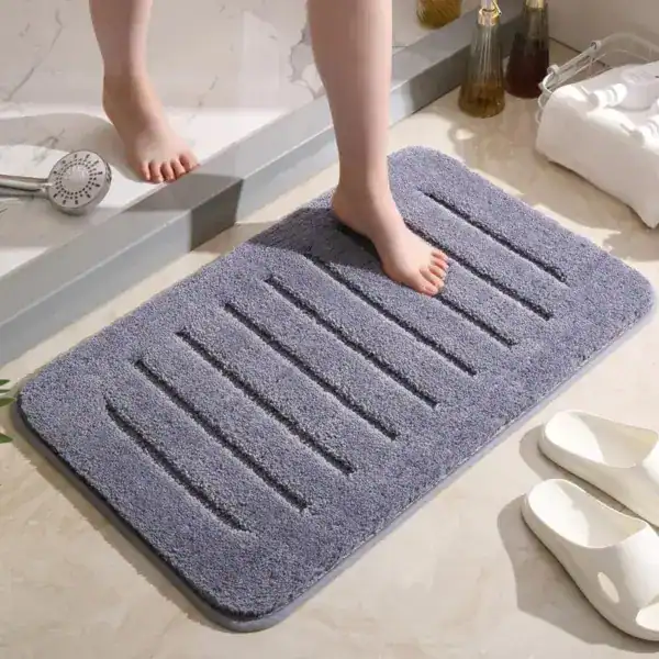 Donkergrijze badmat met antislip structuur in de badkamer.