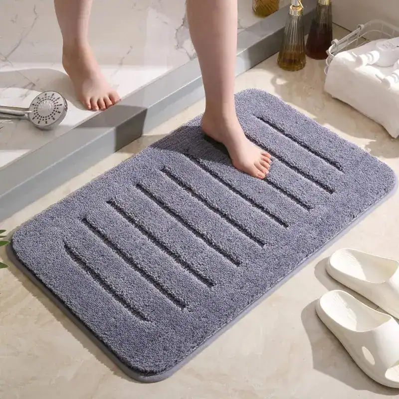Donkergrijze badmat met antislip structuur in de badkamer.