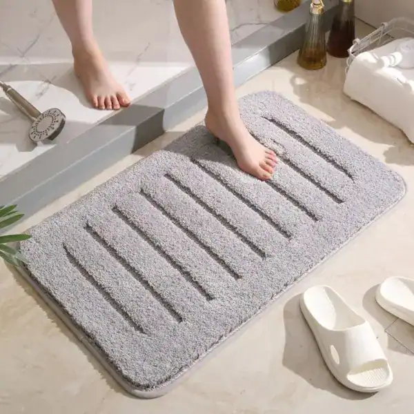 Donkergrijze badmat met antislip structuur in de badkamer.