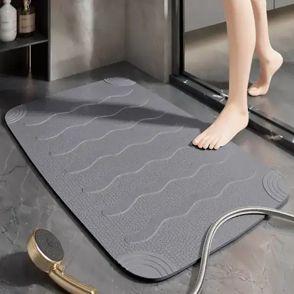 Grijze antislip douchemat voor inloopdouche met golfvormige textuur.