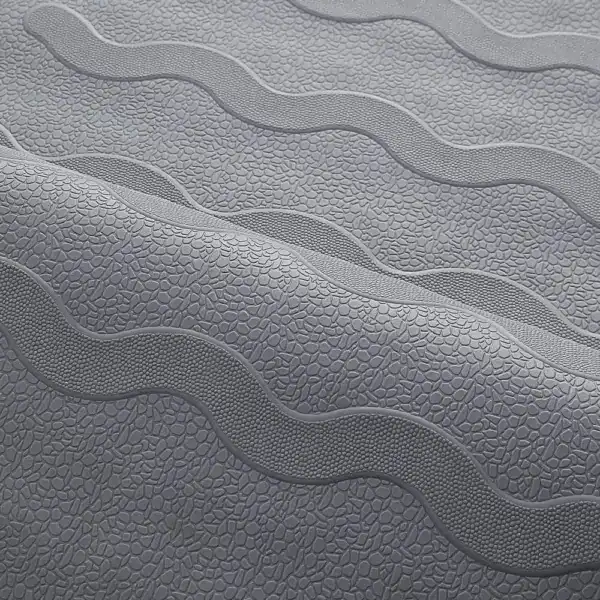 Grijze douchemat met antislip textuur en golfvormige reliëfpatronen.