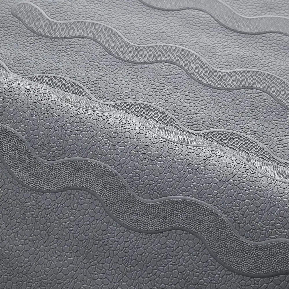 Grijze douchemat met antislip textuur en golfvormige reliëfpatronen.