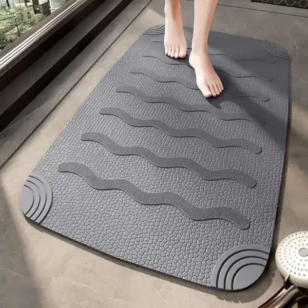 Grijze antislip douchemat voor inloopdouche met golfvormige textuur.