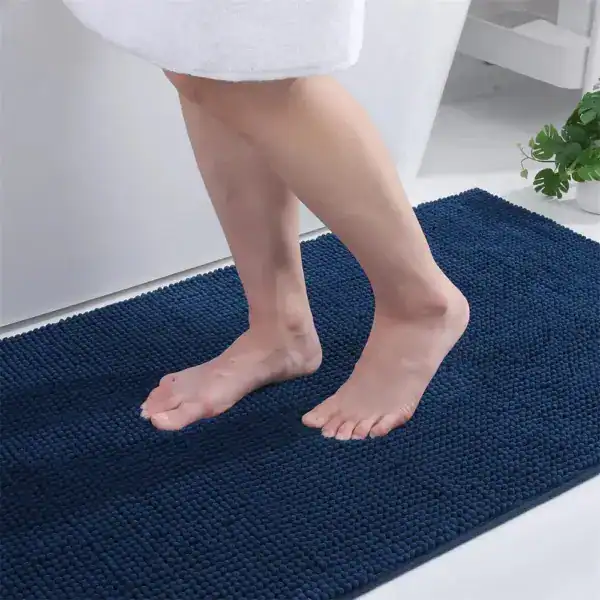 Donkerblauwe dunne badmat met antislip textuur voor badkamer.