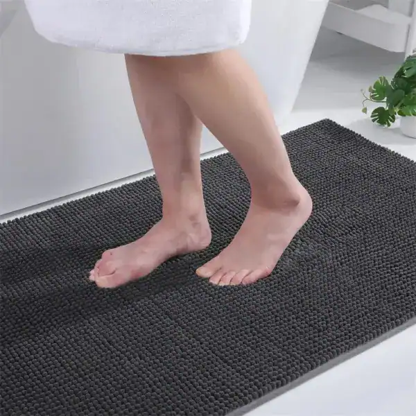 Donkergrijze dunne badmat met antislip textuur voor badkamer.