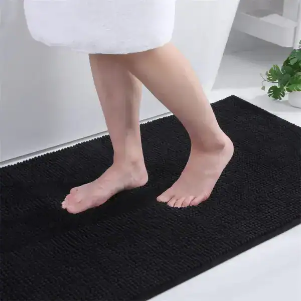 Zwarte dunne badmat met antislip textuur voor de badkamer.