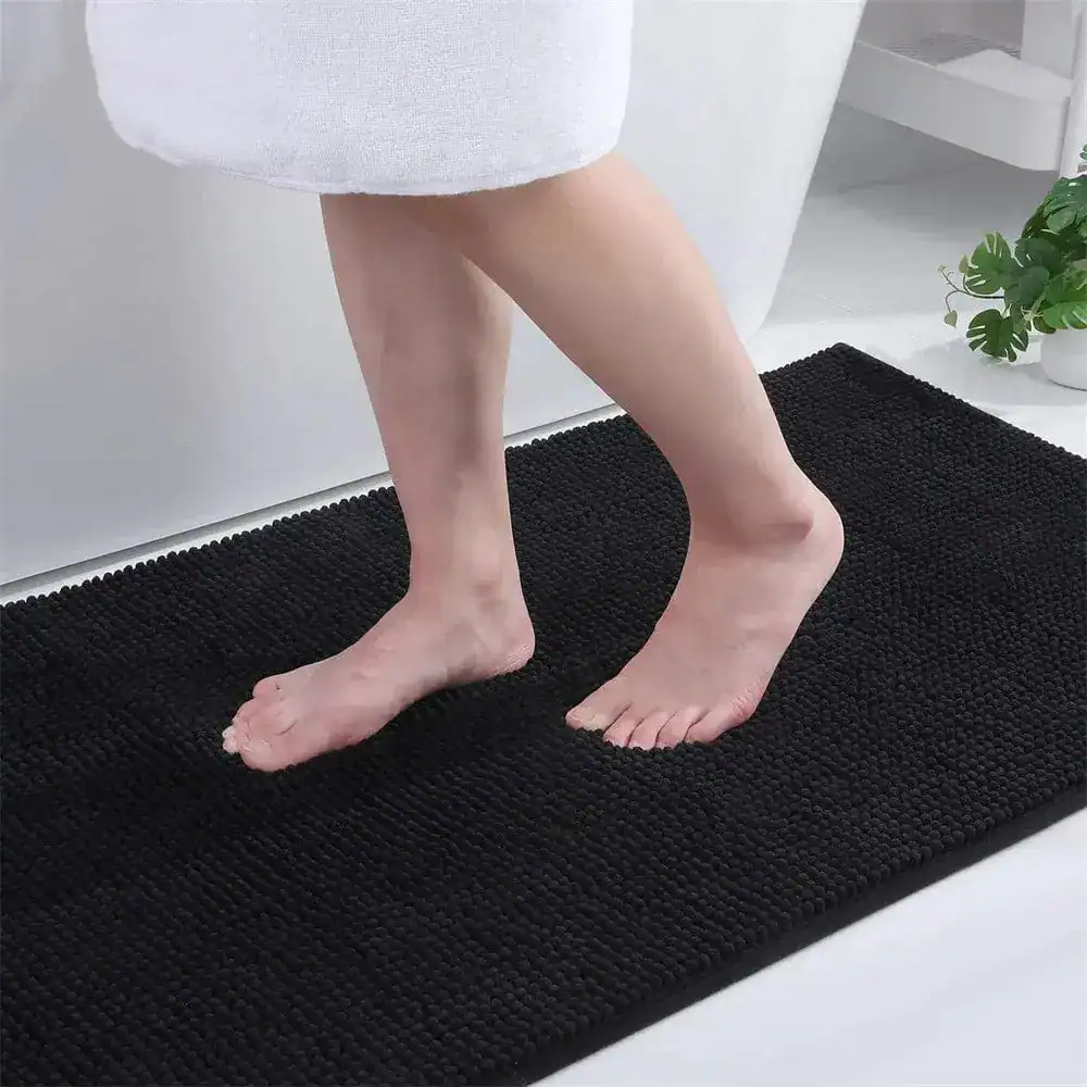 Zwarte dunne badmat met antislip textuur voor de badkamer.
