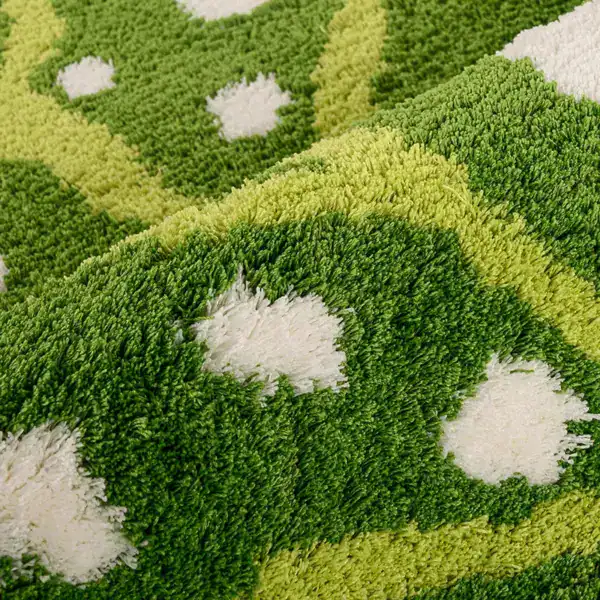 Groene en witte badmat met antislip textuur en geometrisch patroon.