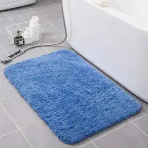 Blauwe fluffy badmat voor de badkamer met antislip eigenschappen.