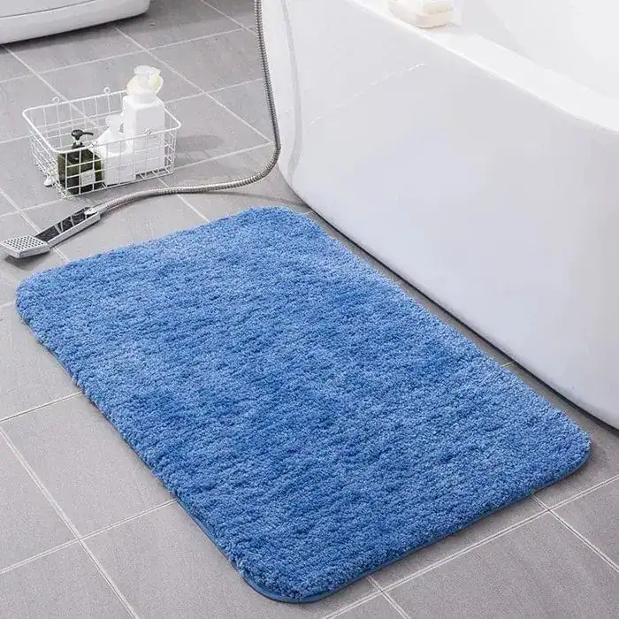 Blauwe fluffy badmat voor de badkamer met antislip eigenschappen.