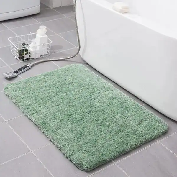 Groene fluffy badmat voor de badkamer met antislip eigenschappen.