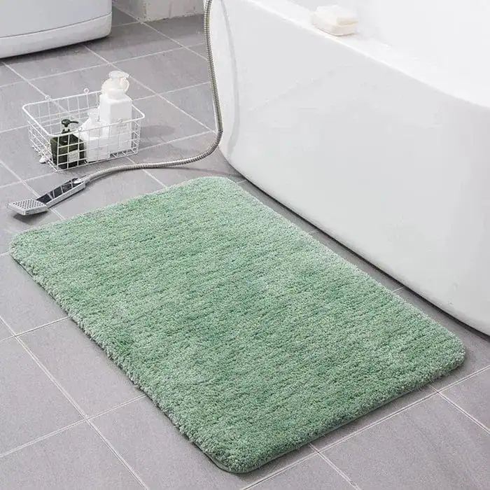 Groene fluffy badmat voor de badkamer met antislip eigenschappen.