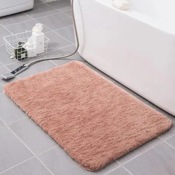 Fluffige badmat in roze kleur, geschikt als badkamermat of douchemat.