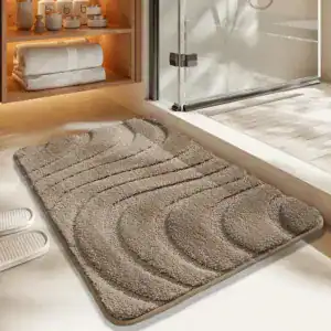 Getufte badmat met golfvormige textuur in beige, voor badkamer en douche.