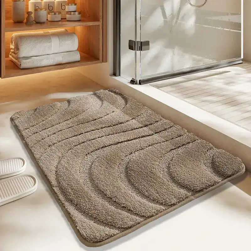 Getufte badmat met golfvormige textuur in beige, voor badkamer en douche.