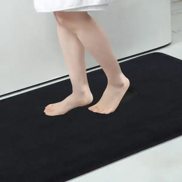 Grote zwarte badmat met antislip effect in de badkamer.