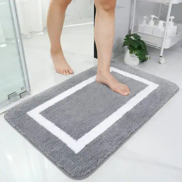 Grote dikke badmat met witte rand, antislip, voor badkamer en douche.