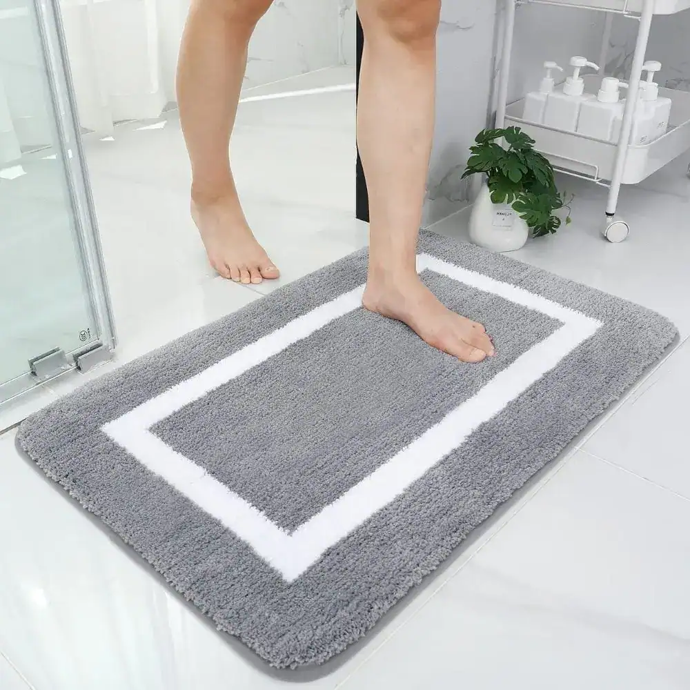 Grote dikke badmat met witte rand, antislip, voor badkamer en douche.