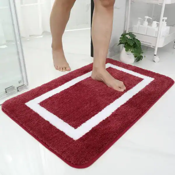 Grote dikke badmat in bordeauxrood met witte rand, antislip voor badkamer.
